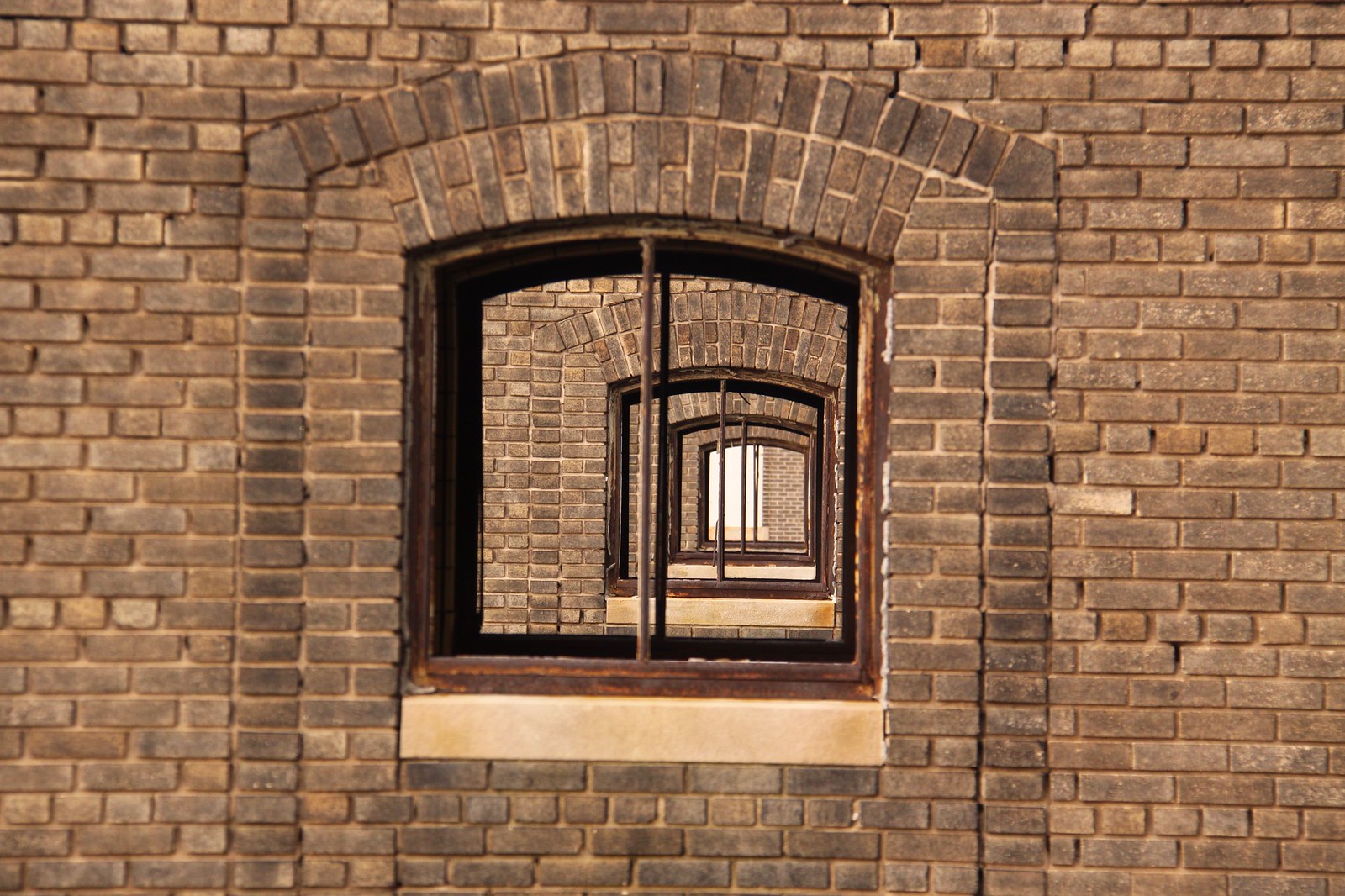 Recursively nested arched brick windows creating an infinite tunnel effect at Buffalo Central Terminal.