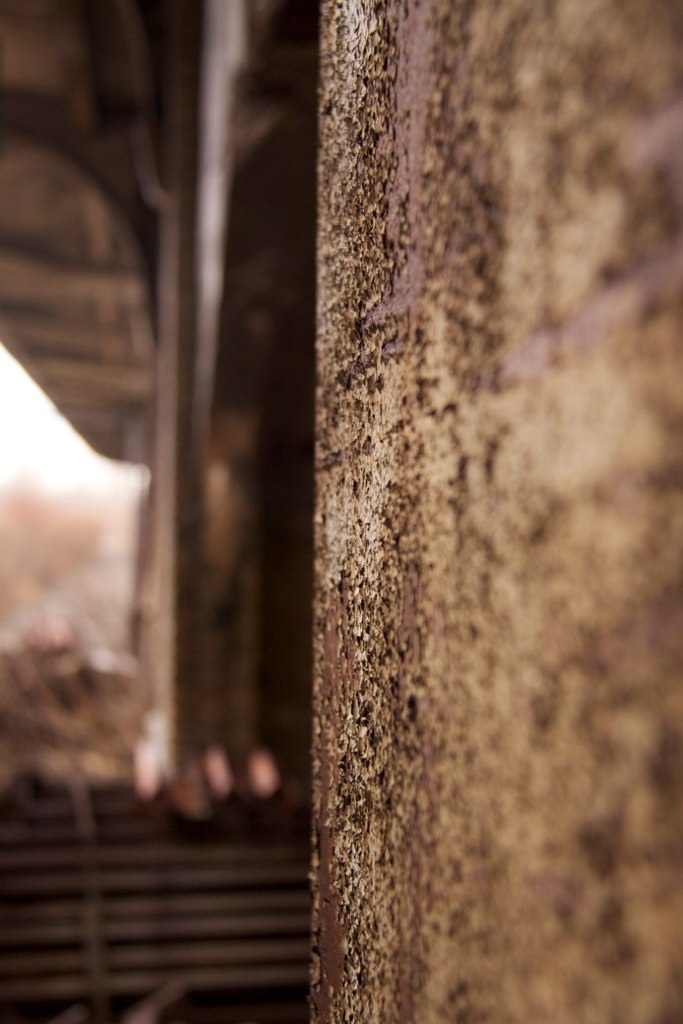 Close-up of a weathered, rust-streaked platform edge under the abandoned Buffalo Central Terminal's canopy.
