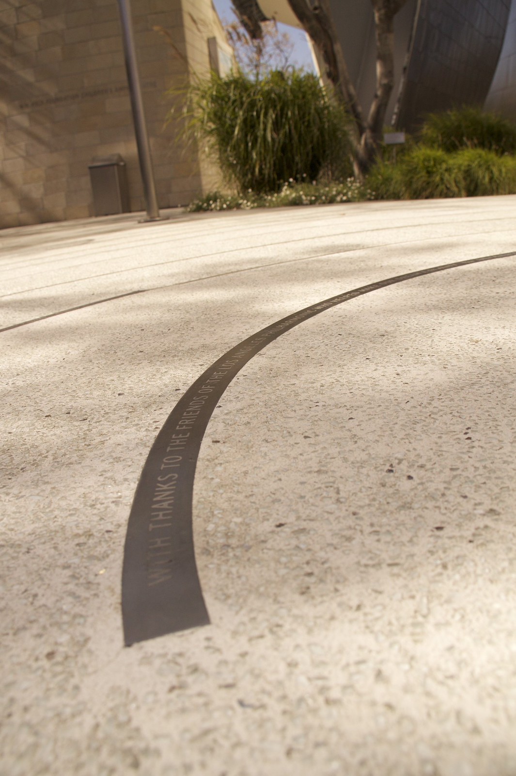 A curved metal inlay in a concrete plaza reads "WITH THANKS TO THE FRIENDS OF THE LOS ANGELES PHILHARMONIC.
