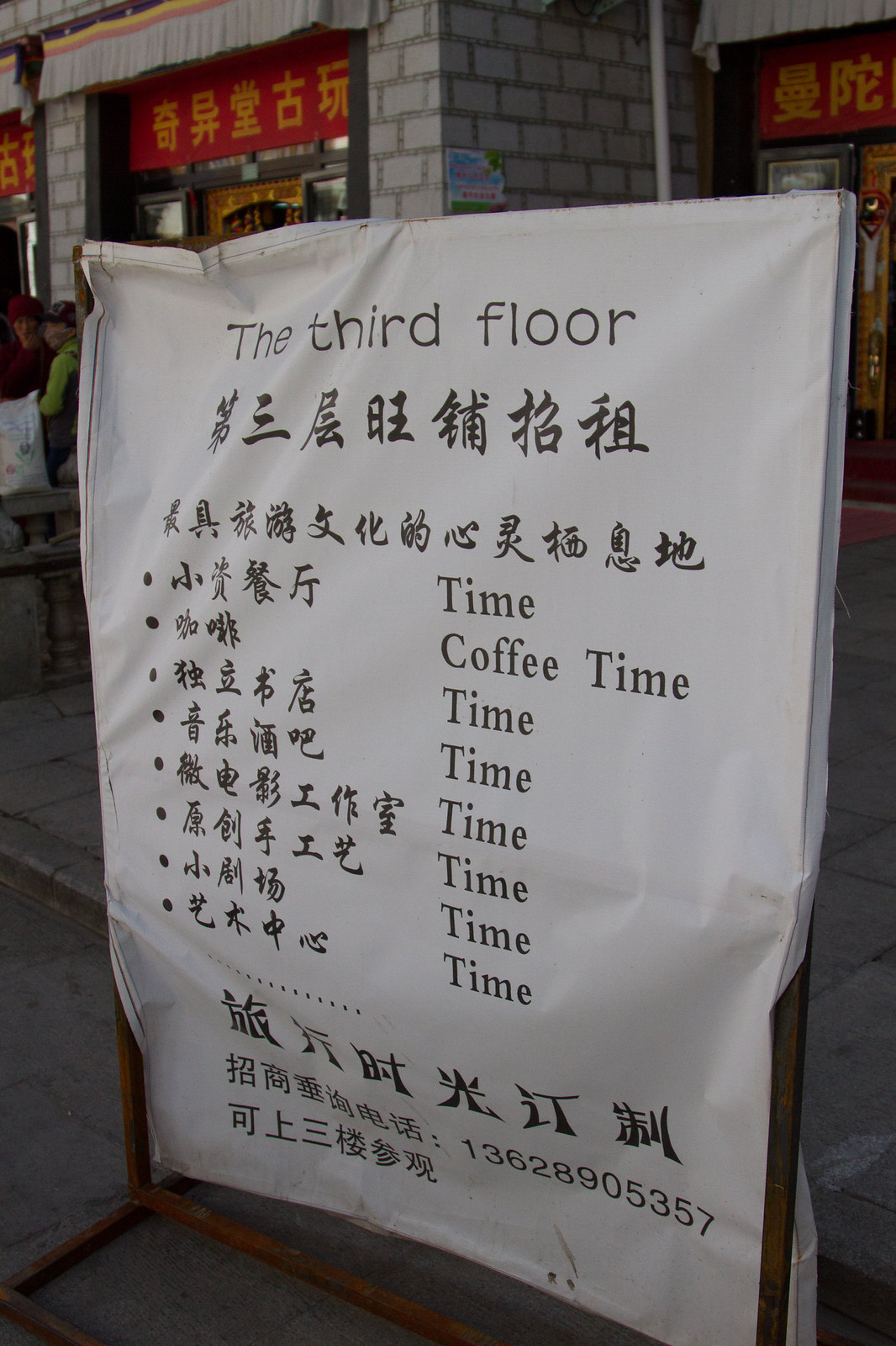 A street sign in Chinese and English reading "The third floor," listing "Coffee Time" and shops for rent.